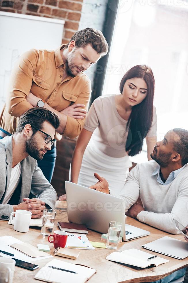 Concentrated at work. Group of young business people discussing something in office photo