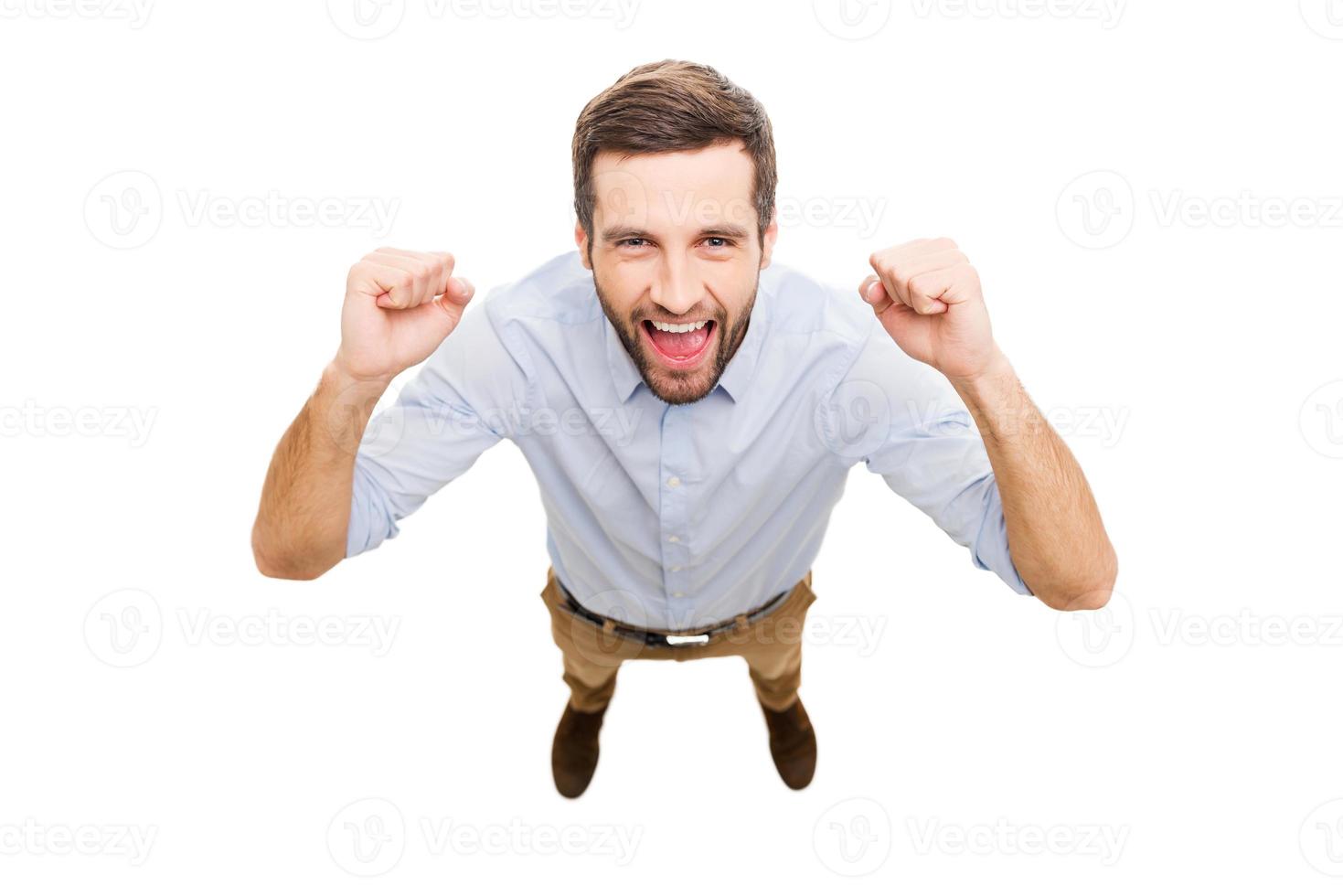 Everyday winner. Top view of happy young man expressing positivity and gesturing while standing isolated on white background photo