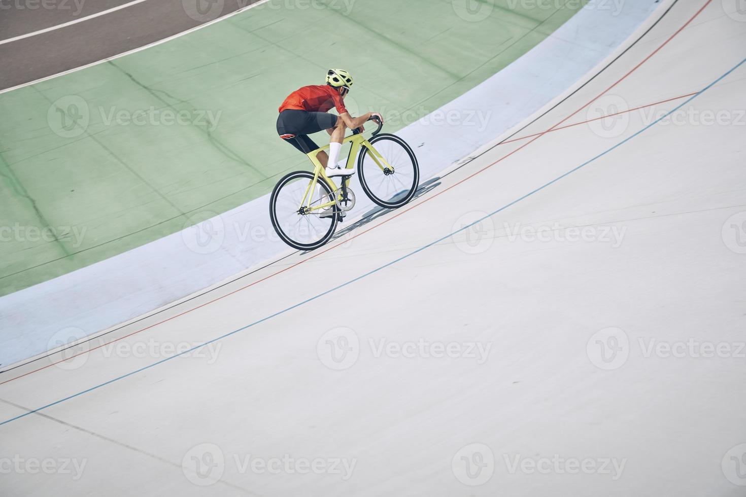 Top view of man in sports clothing cycling on track outdoors photo