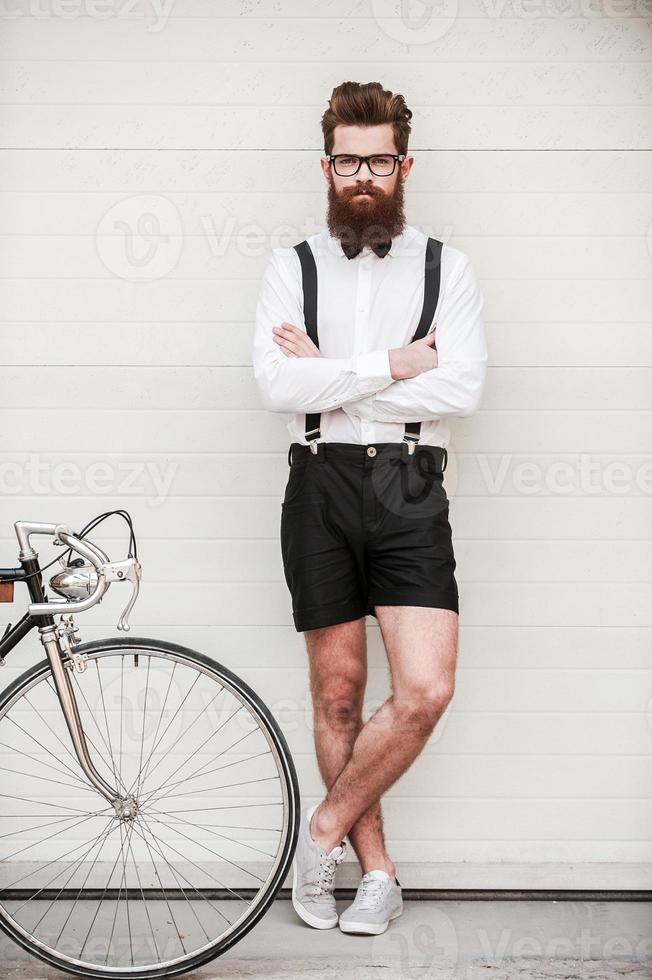 In his own style. Full length of confident young bearded man keeping arms crossed and looking at camera while standing outdoors photo