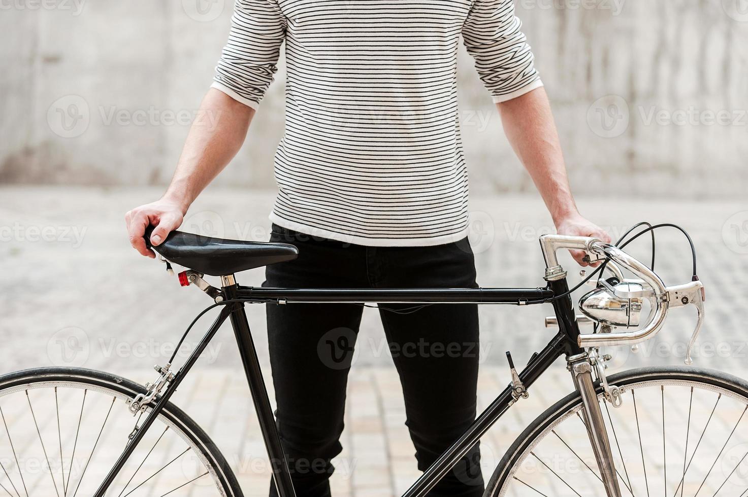 orgulloso de su bicicleta. primer plano, de, joven, manos de valor en cartera, en, el suyo, bicicleta, mientras, posición, aire libre foto