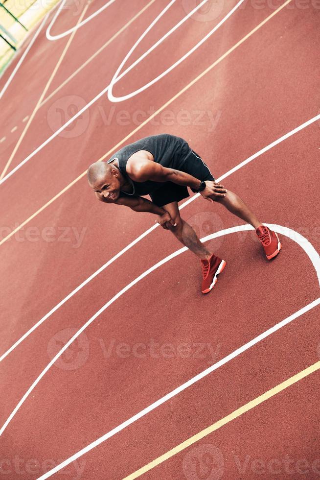 Taking a moment to rest. Top view of young African man in sports clothing taking a break while playing basketball outdoors photo