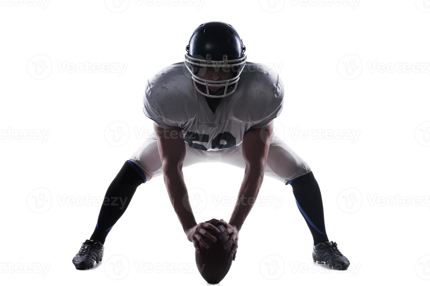 Starting the game.  American football player getting ready before starting the game while standing against white background photo