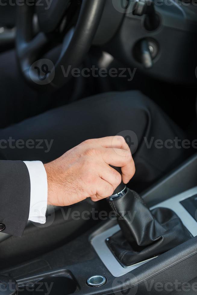 Driving a car. Close-up of man in formalwear driving car photo