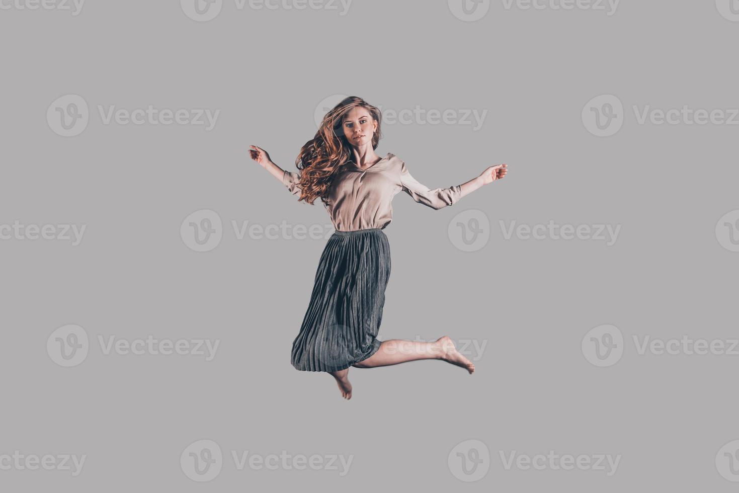 Moving free. Studio shot of attractive young woman hovering in air photo