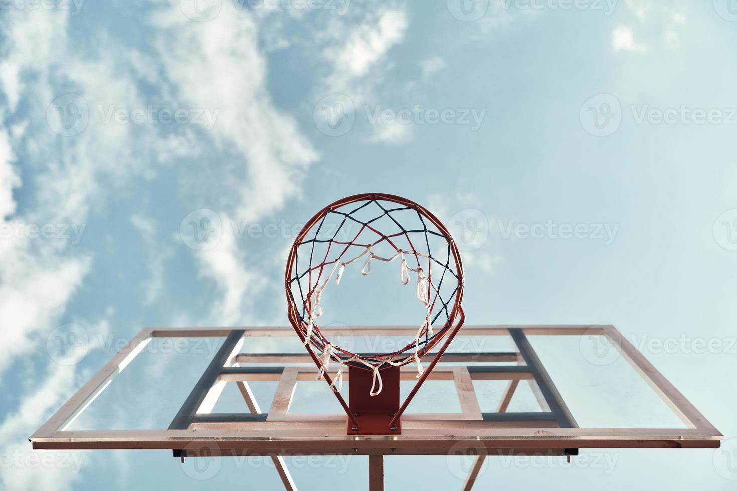 Outdoors fun. Shot of basketball hoop with sky in the background outdoors photo