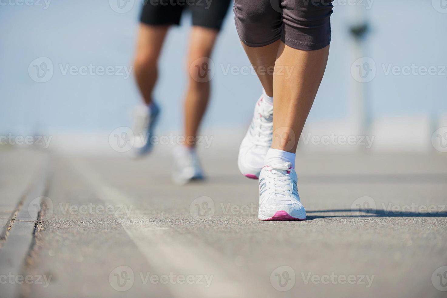 People running.  Close-up image of woman and man running along the running track photo