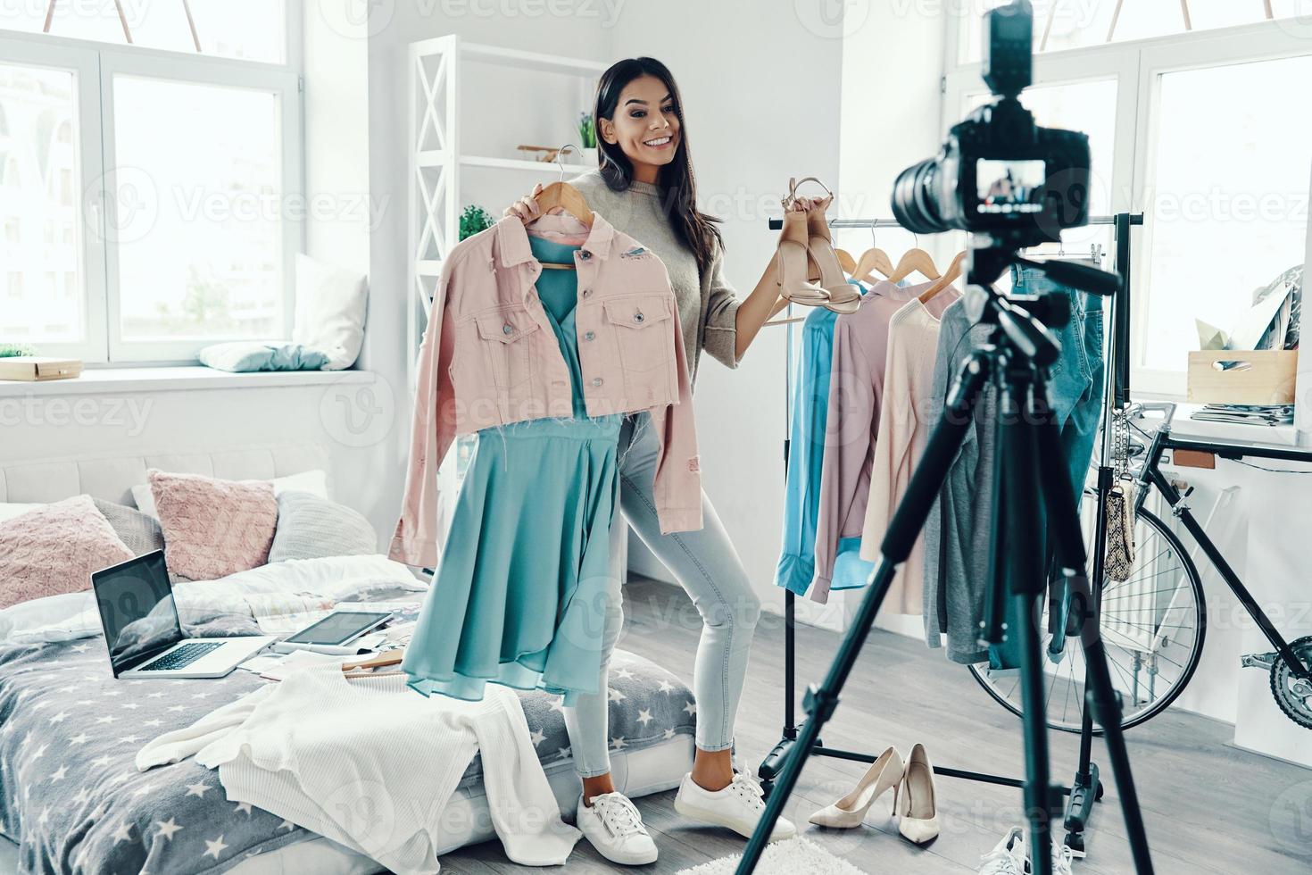 Full length of beautiful young woman in casual clothing making social media video while spending time at home photo