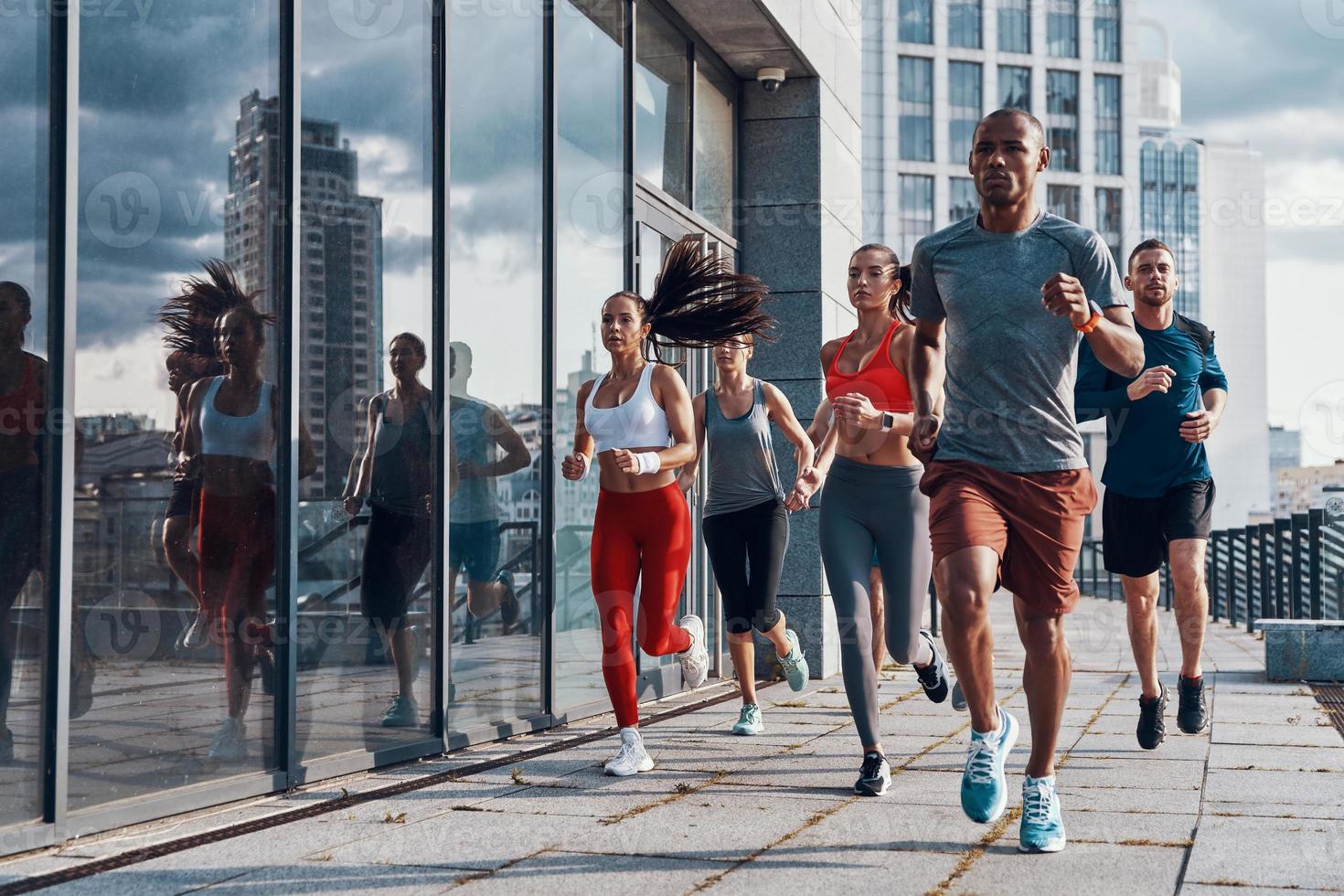 toda la longitud de la gente con ropa deportiva trotando mientras