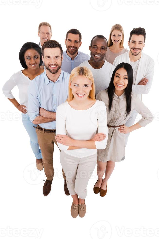 Proudly successful. Top view of positive diverse group of people in smart casual wear looking at camera and smiling while standing close to each other photo