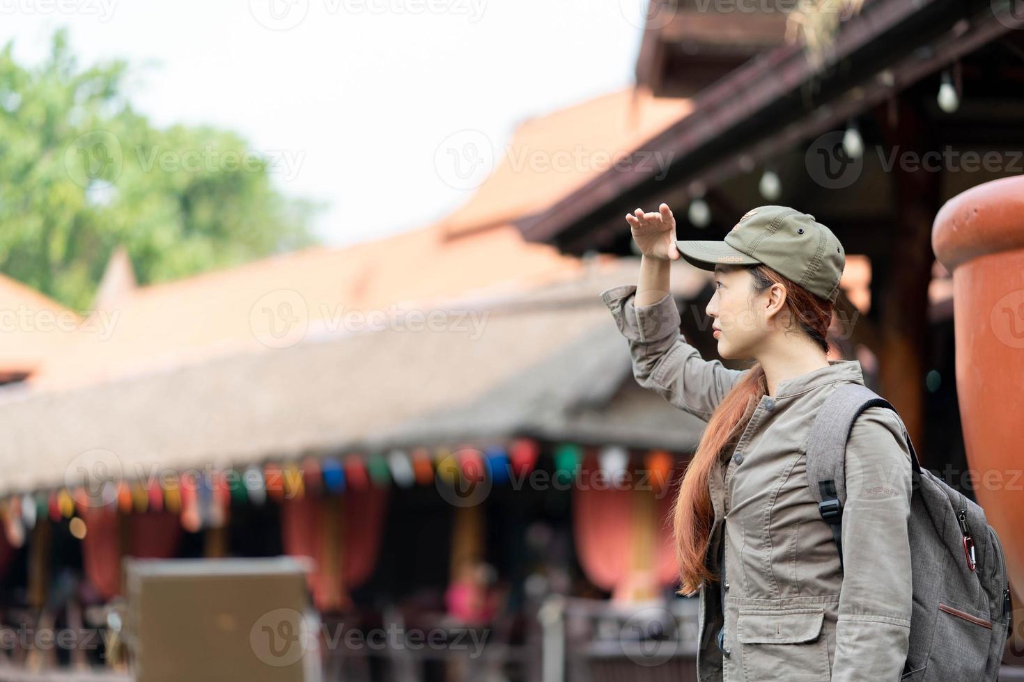 Young asian woman traveler with mask and backpack looking and smile in ayutthaya thailand. Travel Holiday Relaxation Concept photo