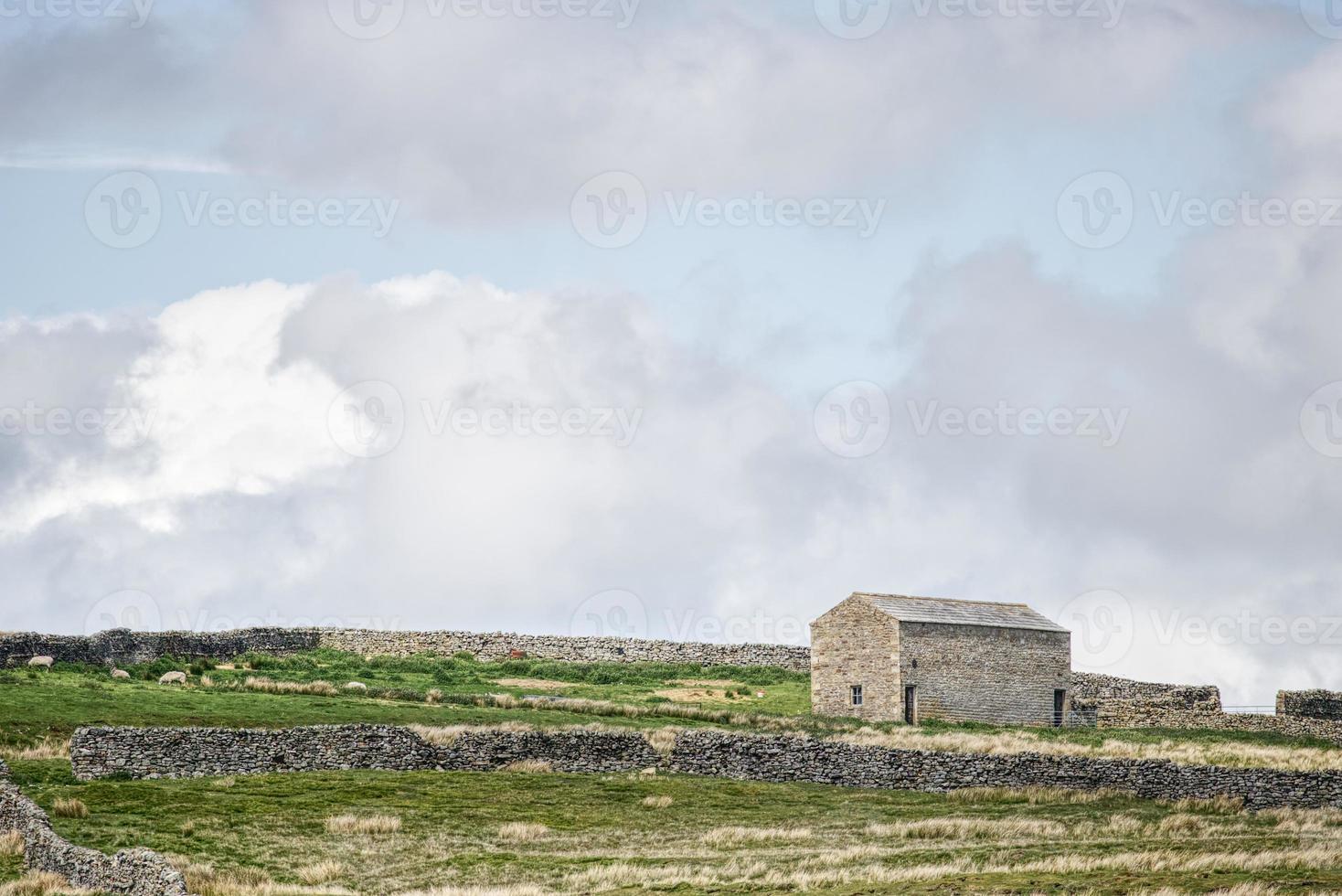 Stone barn with cloudy sky photo