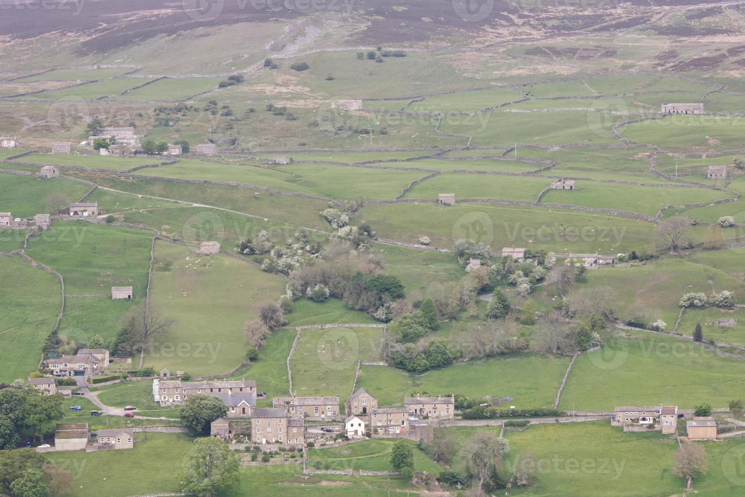 un pueblo de yorkshire dales con colinas y campos foto