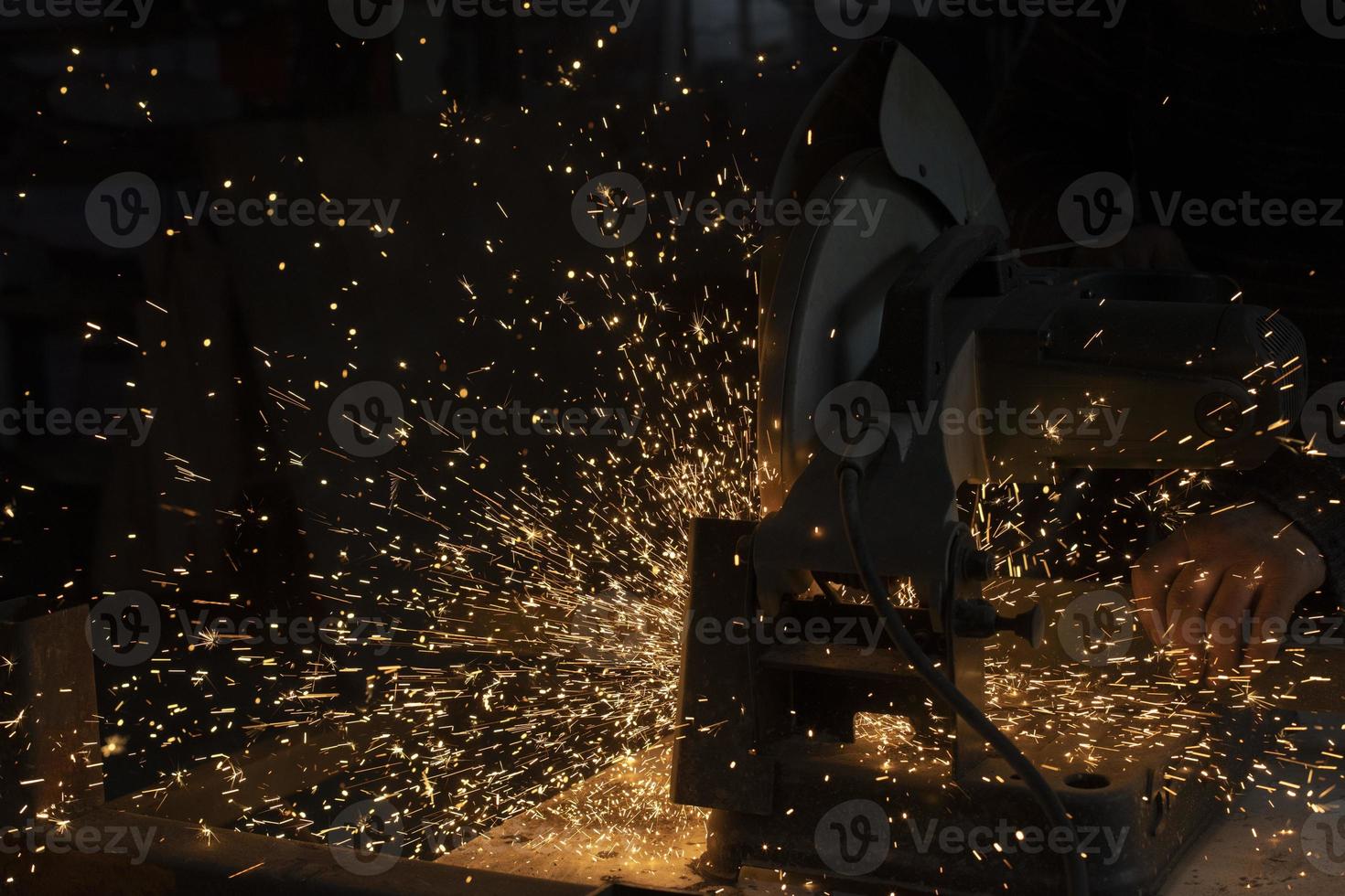 Sparks from metal. Cutting steel. Saw spins quickly. Industrial background. photo