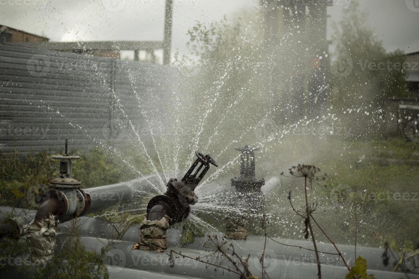 Water pouring out of broken pipe. Pipeline breakthrough. Boiler station accident. photo