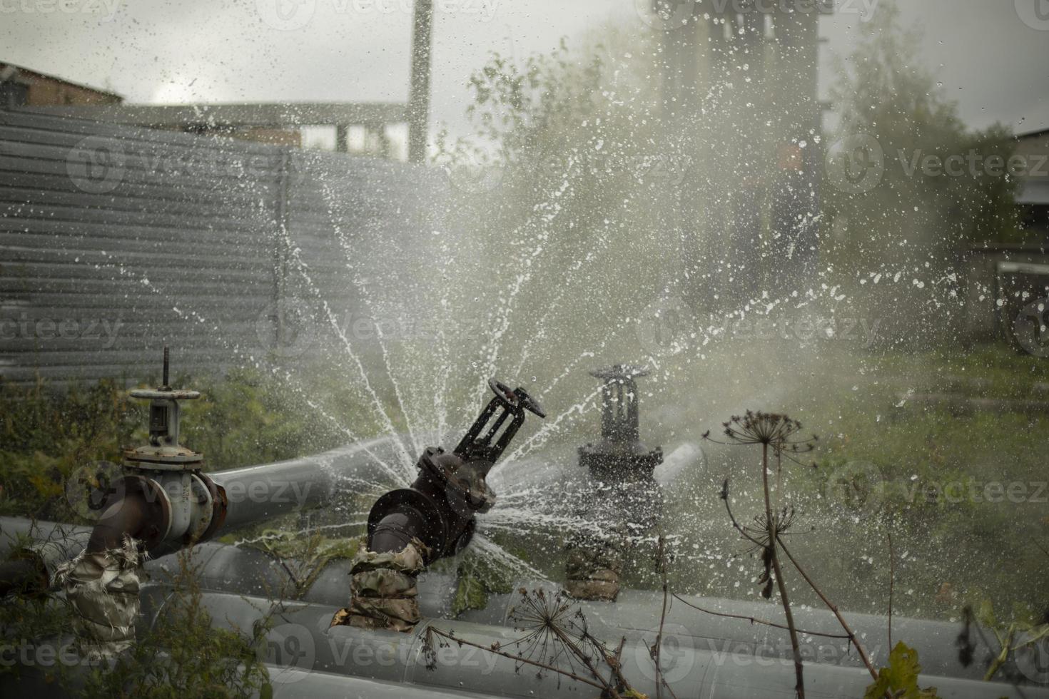 agua saliendo de una tubería rota. avance de la tubería. accidente de la estación de calderas. foto