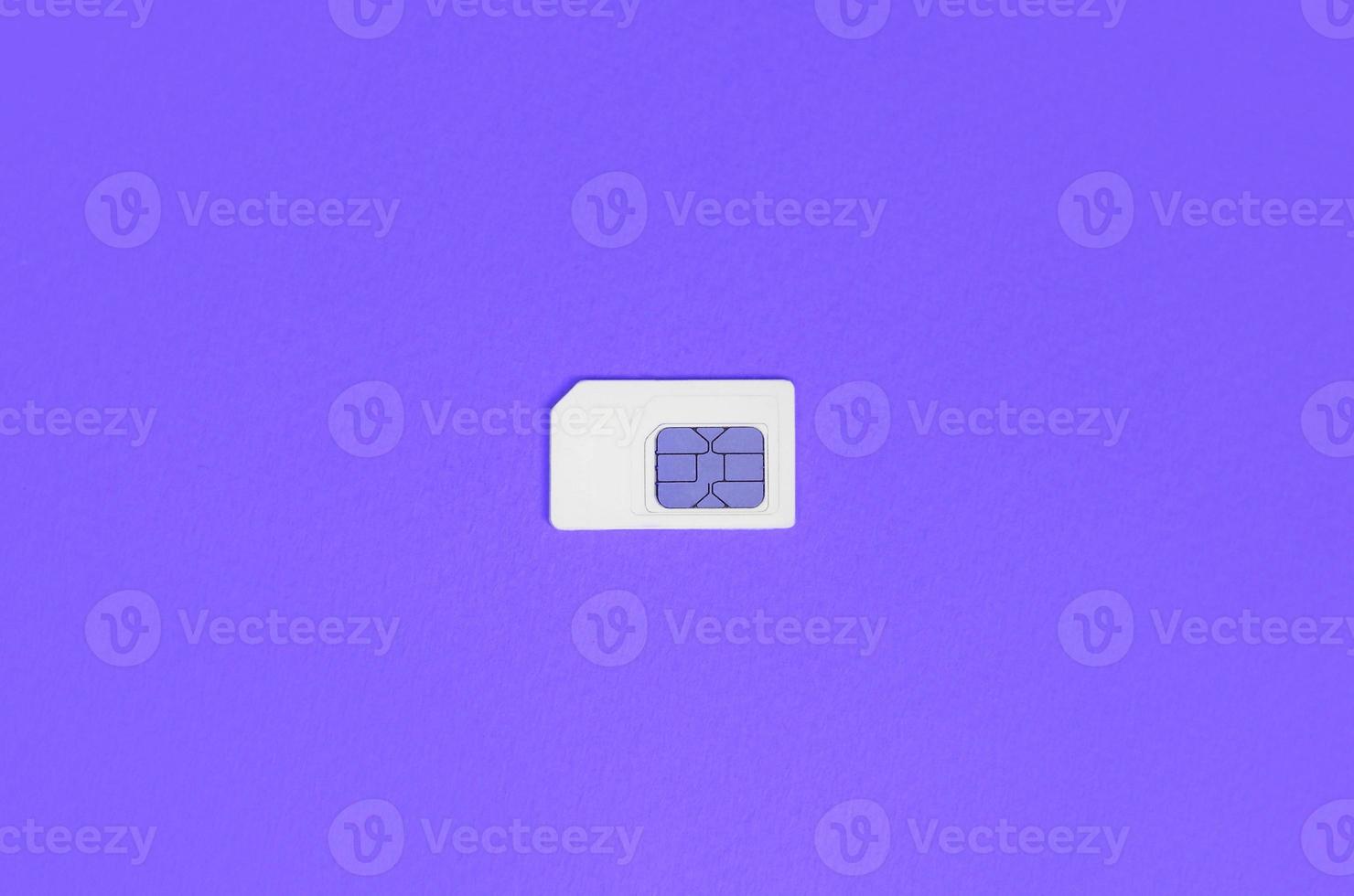 Subscriber identity module. White SIM card on violet background photo