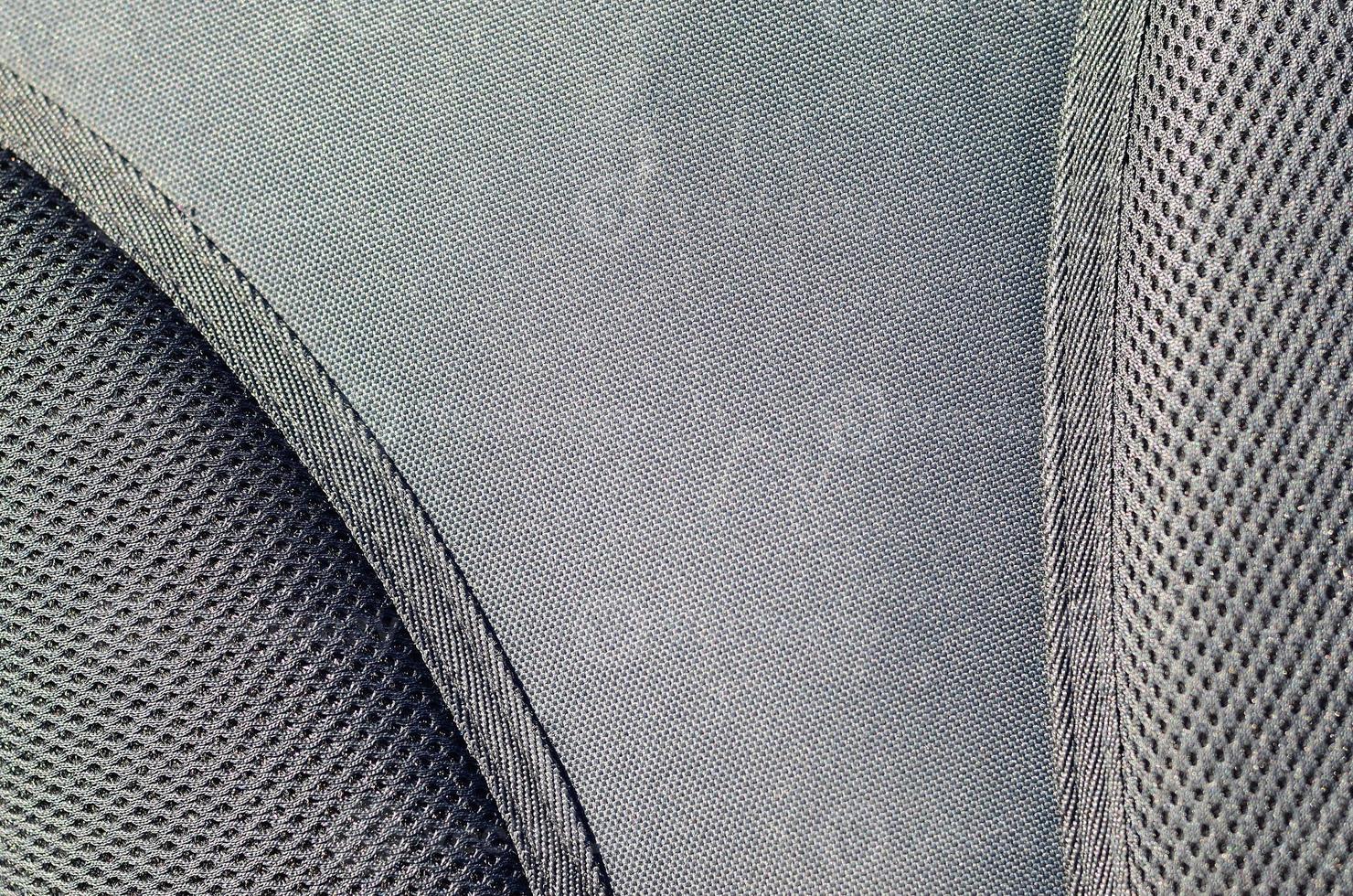closeup of texture breathable mesh fabric in the black photo backpack. Texture of Black Plastic Weave Bag. Background image