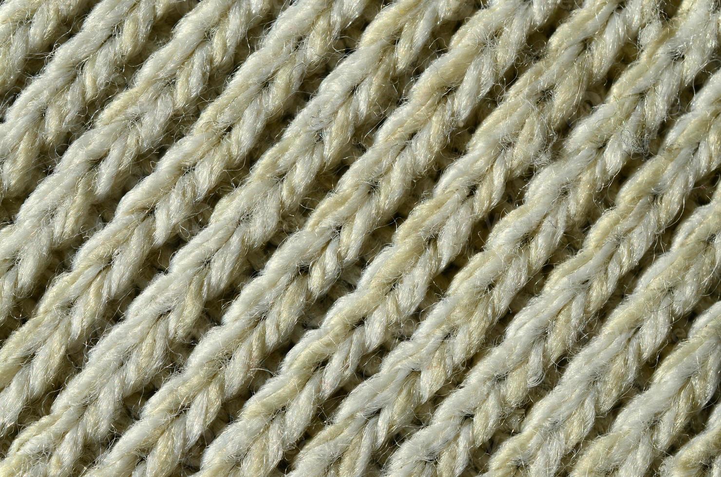 Fabric texture of a soft yellow knitted sweater. Macro image of the structure of bindings in yarns photo