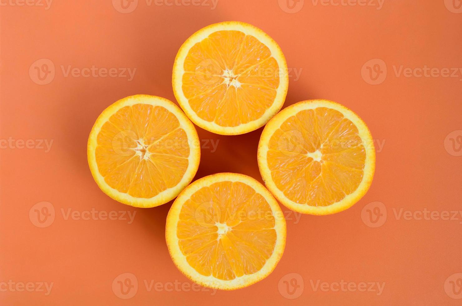 Top view of a several orange fruit slices on bright background in orange color. A saturated citrus texture image photo