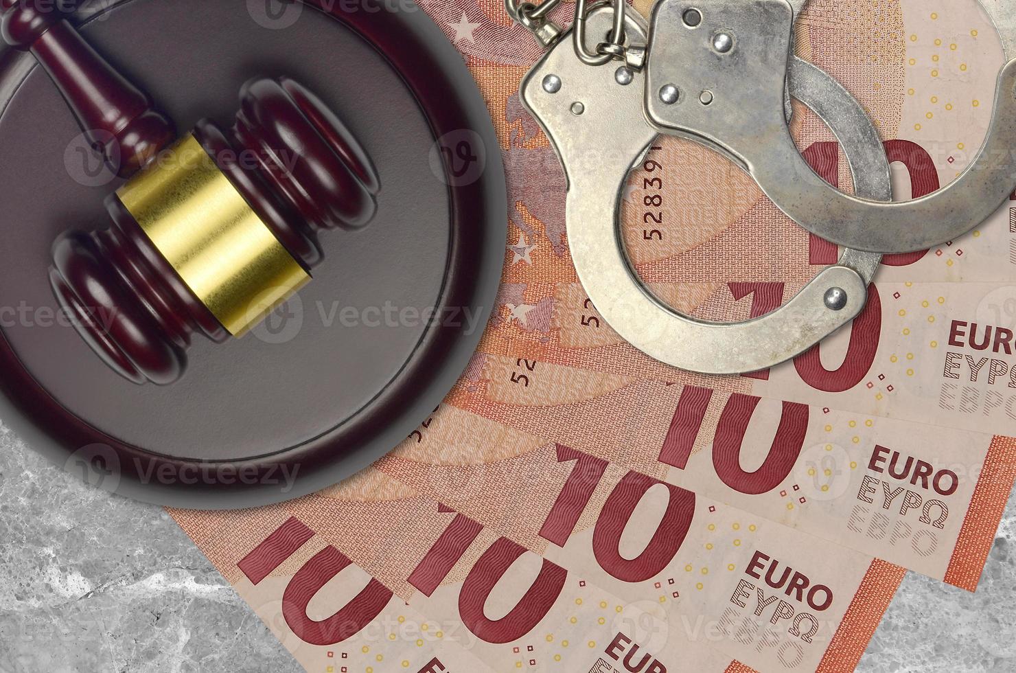 10 euro bills and judge hammer with police handcuffs on court desk. Concept of judicial trial or bribery. Tax avoidance photo