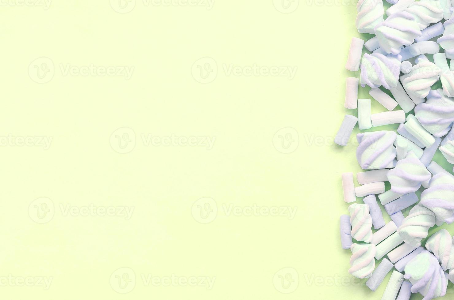 Colorful marshmallow laid out on lime paper background. pastel creative texture photo