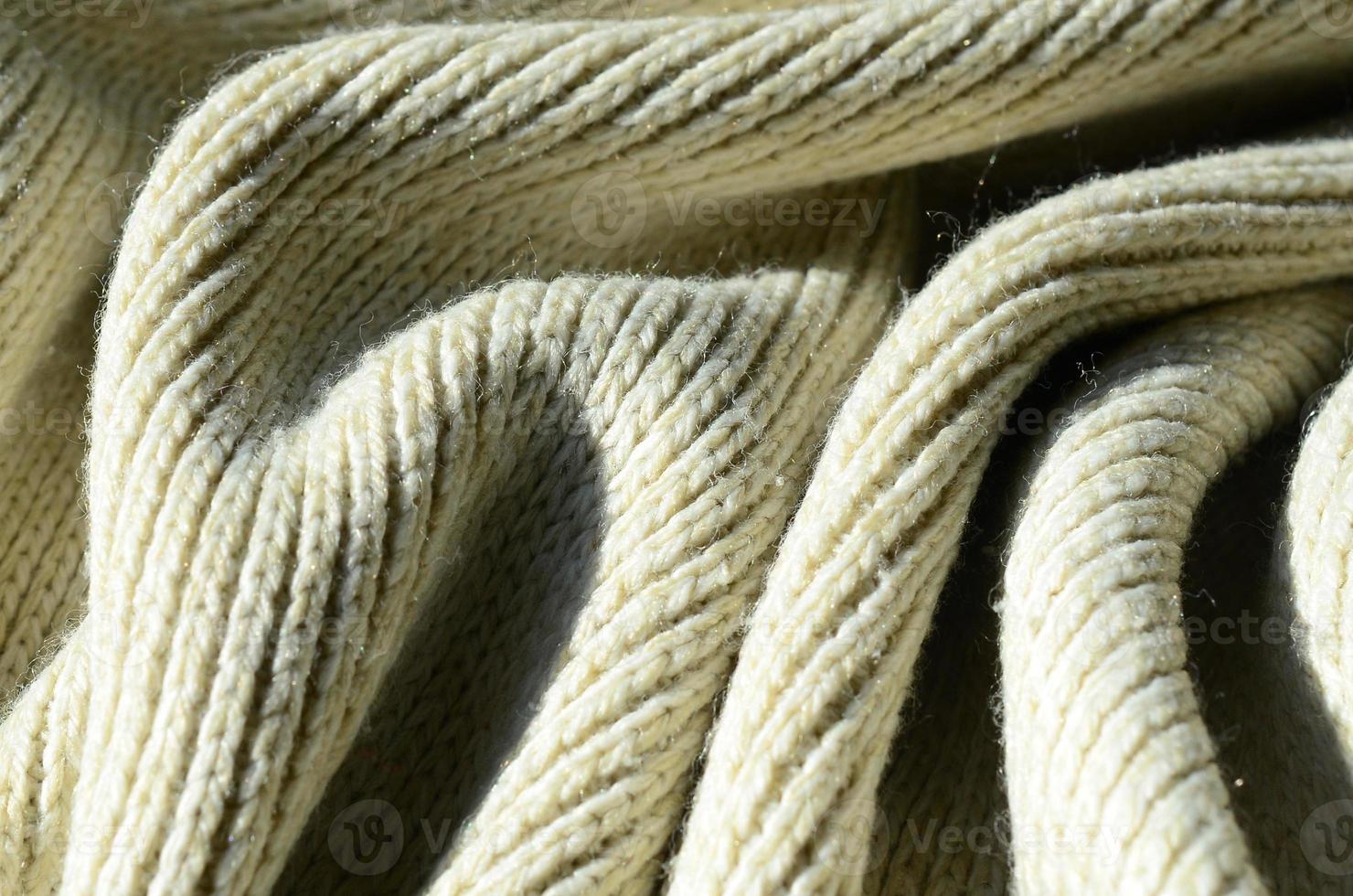 Fabric texture of a soft yellow knitted sweater. Macro image of the structure of bindings in yarns photo