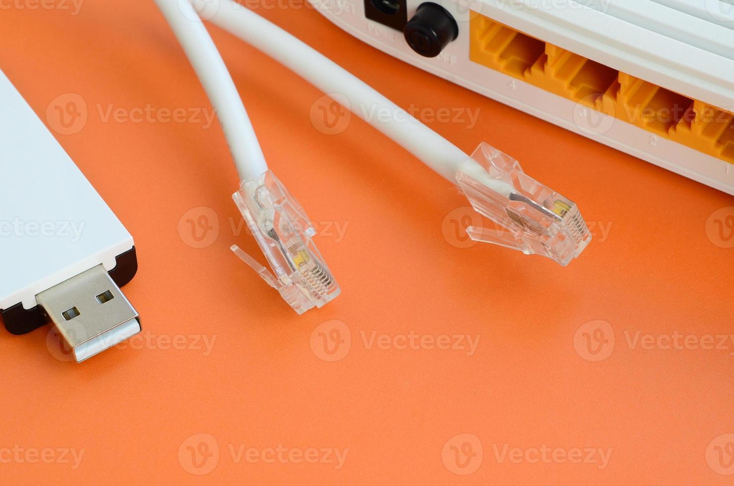 Internet router, portable USB wi-fi adapter and internet cable plugs lie on a bright orange background. Items required for internet connection photo