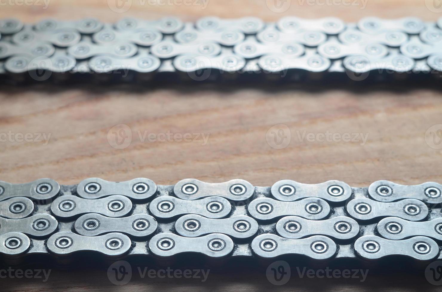 Dirty and oily chain from a mountain bike lying on a wooden table in a bicycle shop photo