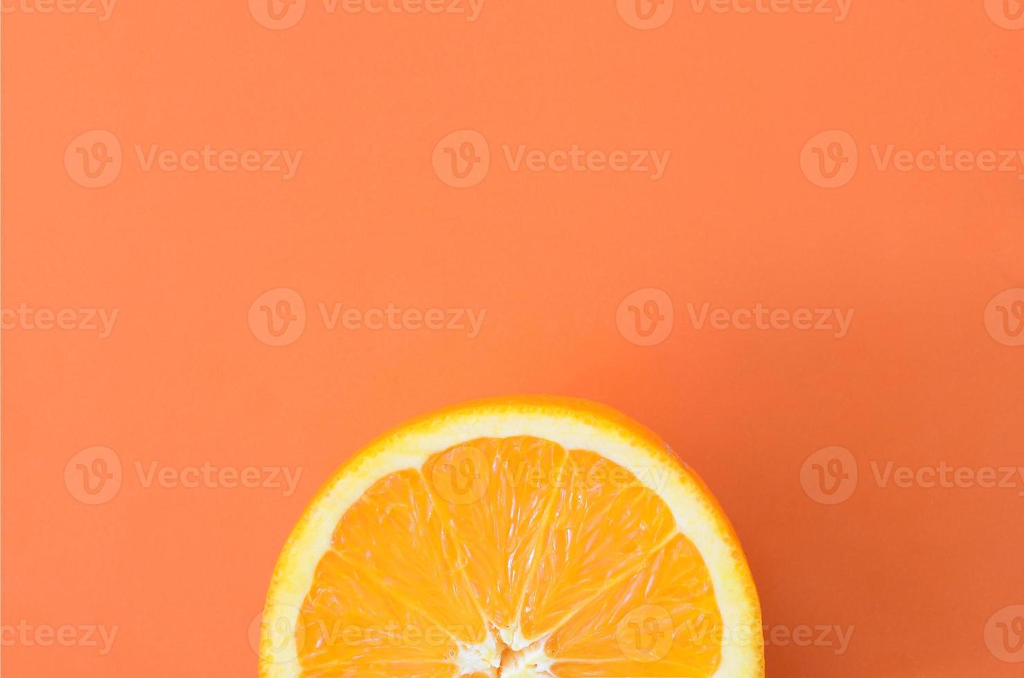 Top view of a one orange fruit slice on bright background in orange color. A saturated citrus texture image photo