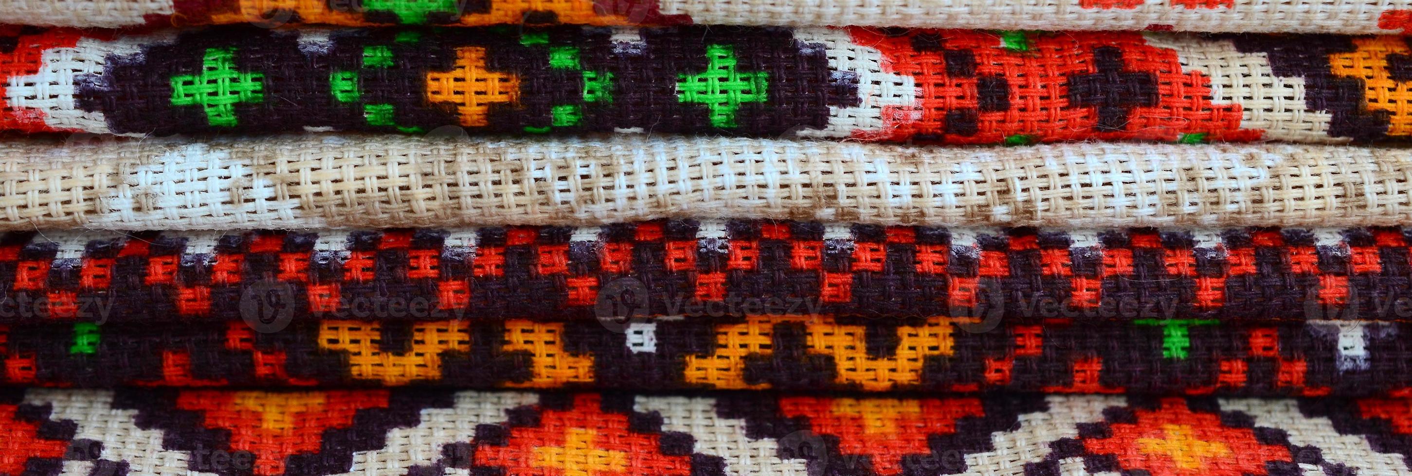 Stack of traditional Ukrainian folk art knitted embroidery patterns on textile fabric photo