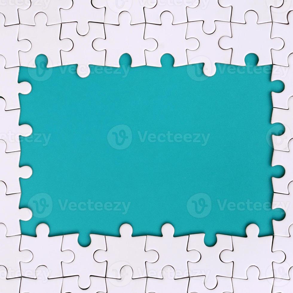 Framing in the form of a rectangle, made of a white jigsaw puzzle around the blue space photo