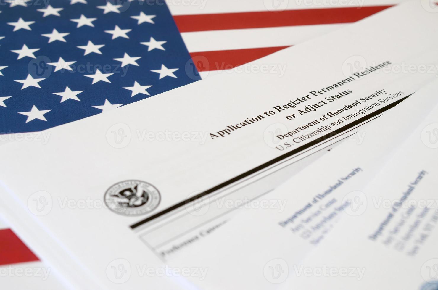 I-485 Application to register permanent residence or adjust status blank form lies on United States flag with envelope from Department of Homeland Security photo