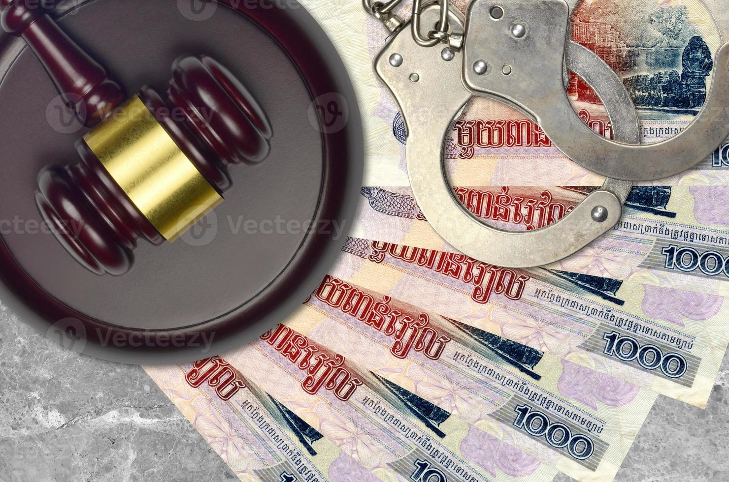 1000 Cambodian riels bills and judge hammer with police handcuffs on court desk. Concept of judicial trial or bribery. Tax avoidance photo