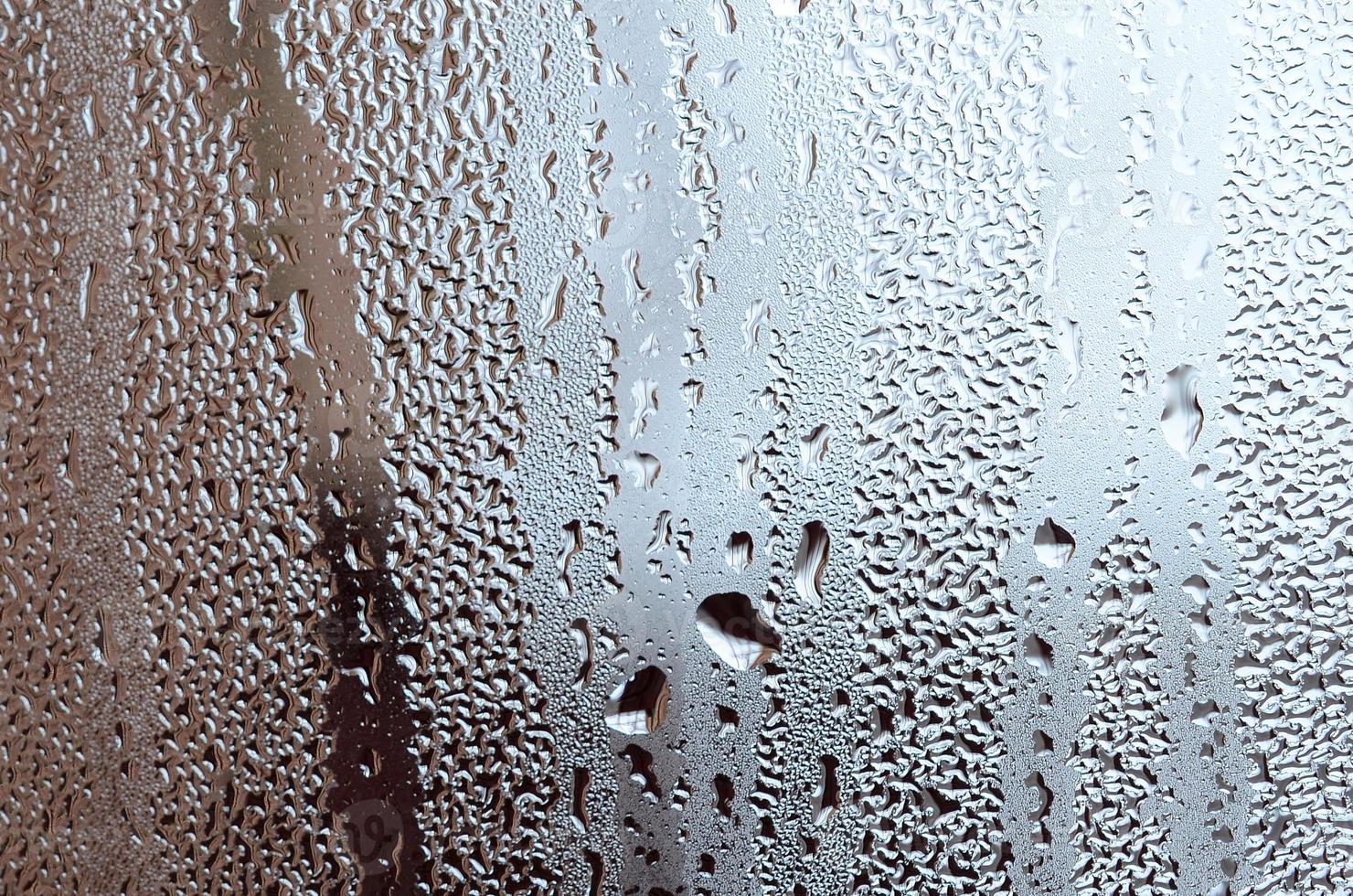Texture of a drop of rain on a glass wet transparent background. Toned in grey color photo