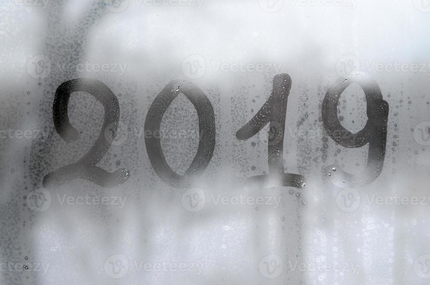 2019. The figures are written on the misted glass in winter photo