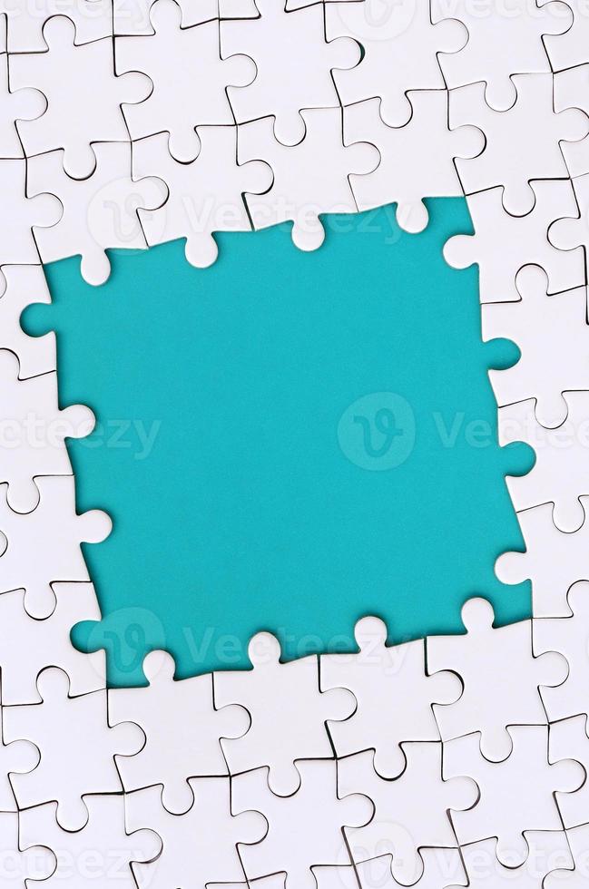 Framing in the form of a rectangle, made of a white jigsaw puzzle around the blue space photo