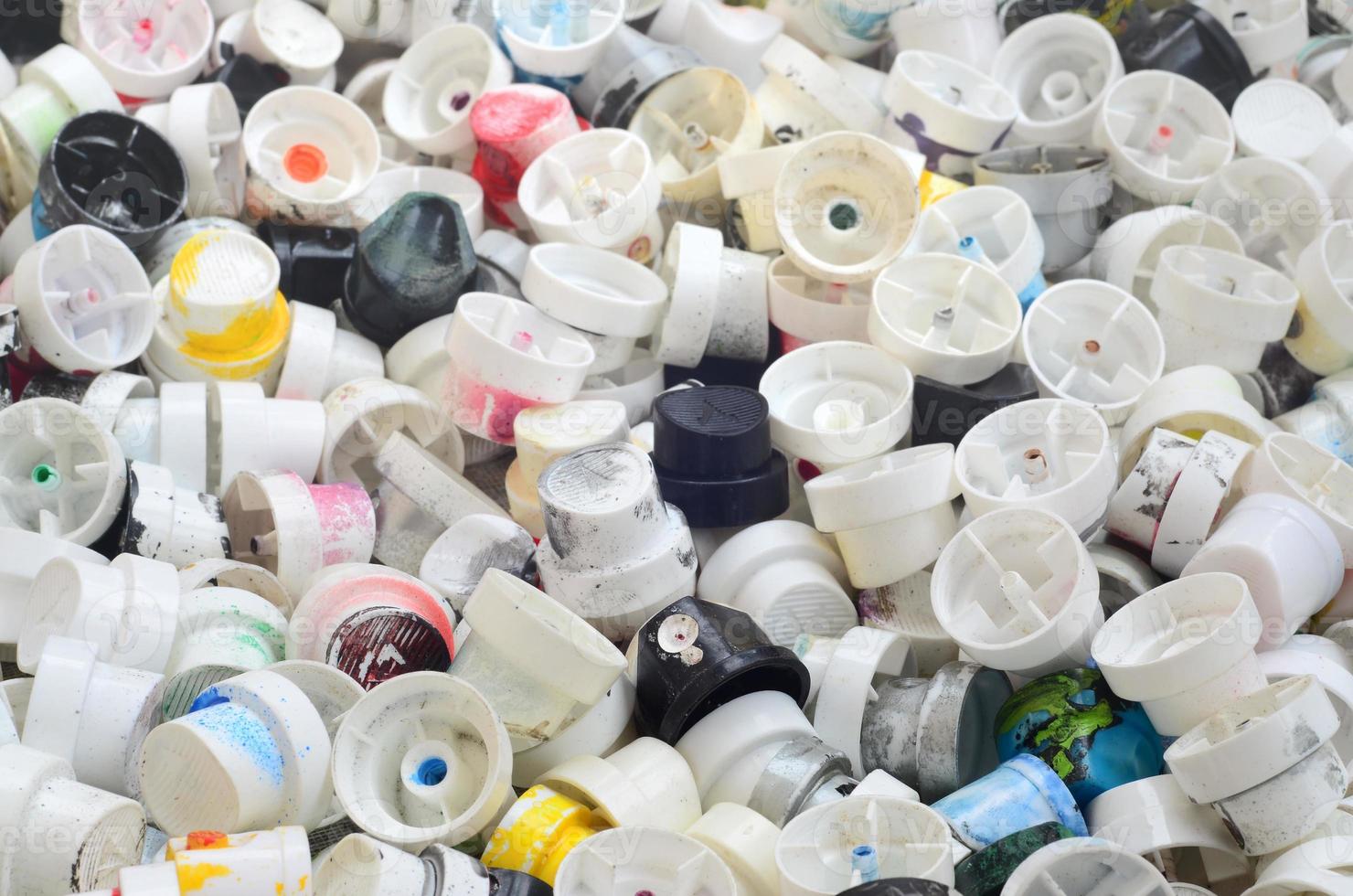 A pattern of many used and soiled nozzles from spray cans with aerosol paint. Background texture of the street art of drawing graffiti on the walls photo