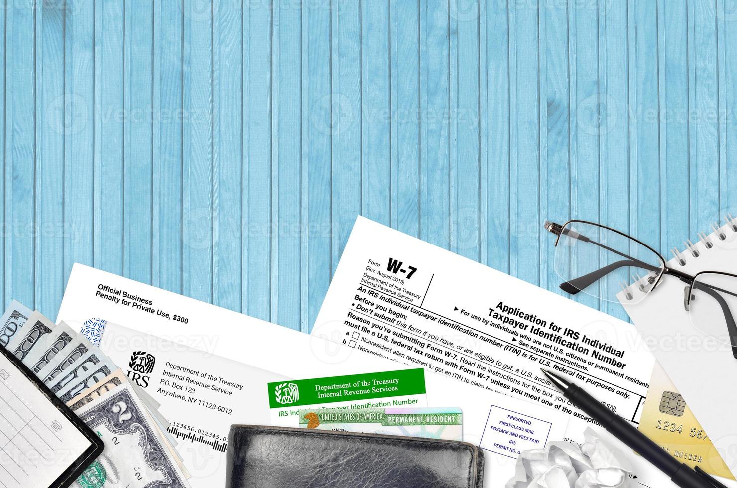 IRS form W-7 Application for IRS individual taxpayer identification number lies on flat lay office table and ready to fill. U.S. Internal revenue services paperwork concept photo