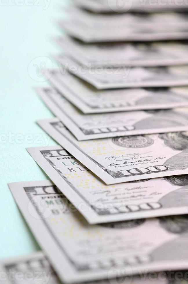 Row of a US dollar bills of a new design lies on a light blue background photo