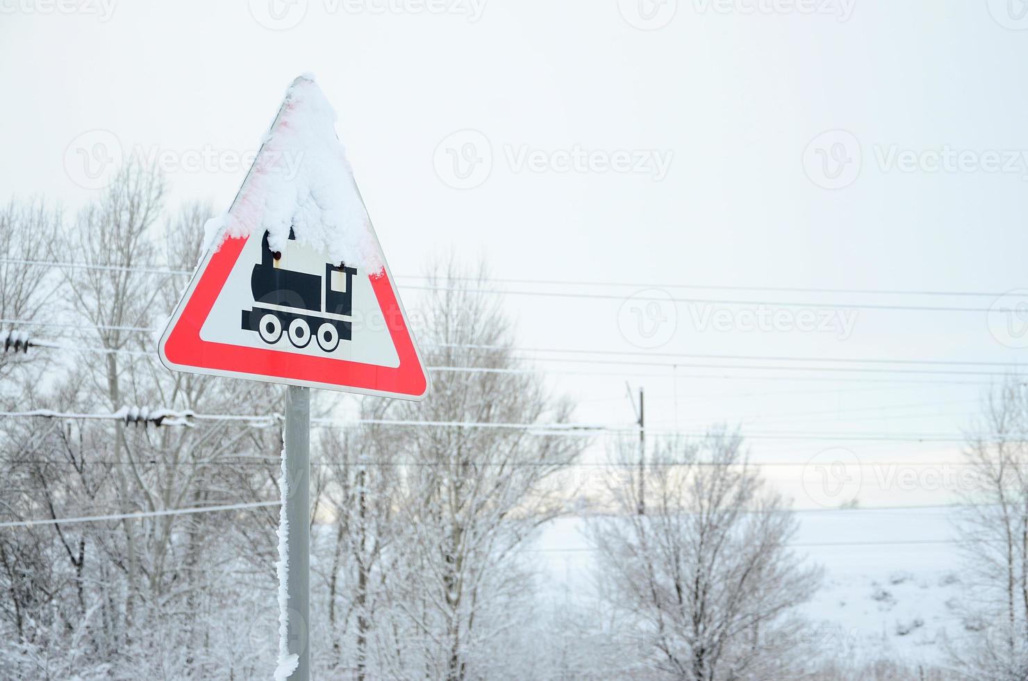 Railway crossing without barrier. A road sign depicting an old black locomotive, located in a red triangle photo