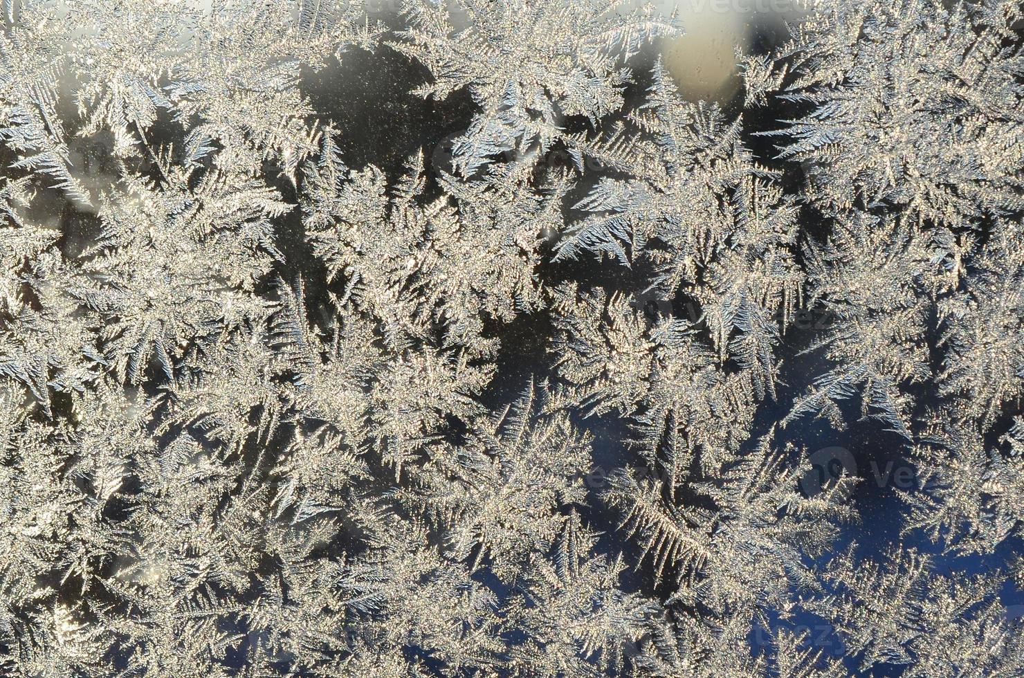 Snowflakes frost rime macro on window glass pane photo