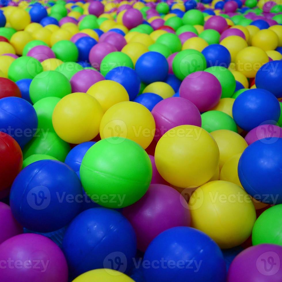 Many colorful plastic balls in a kids' ballpit at a playground. Close up pattern photo
