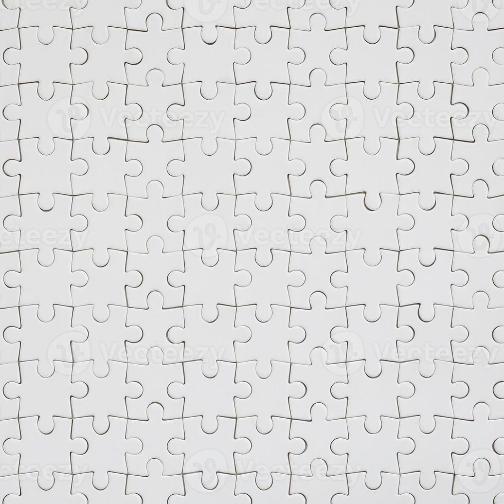 Close up texture of a white jigsaw puzzle in assembled condition. Top view. Many components of a large whole mosaic are united photo