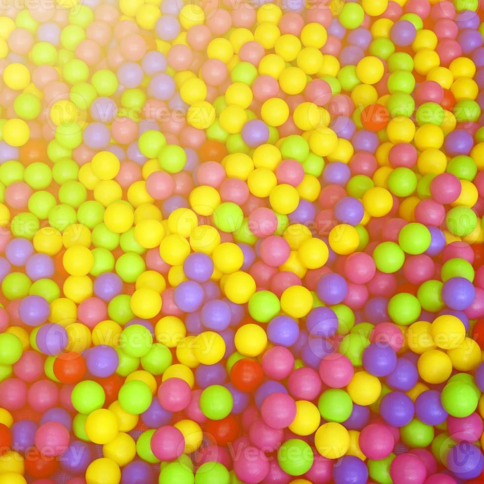 Many colorful plastic balls in a kids' ballpit at a playground. Close up pattern photo