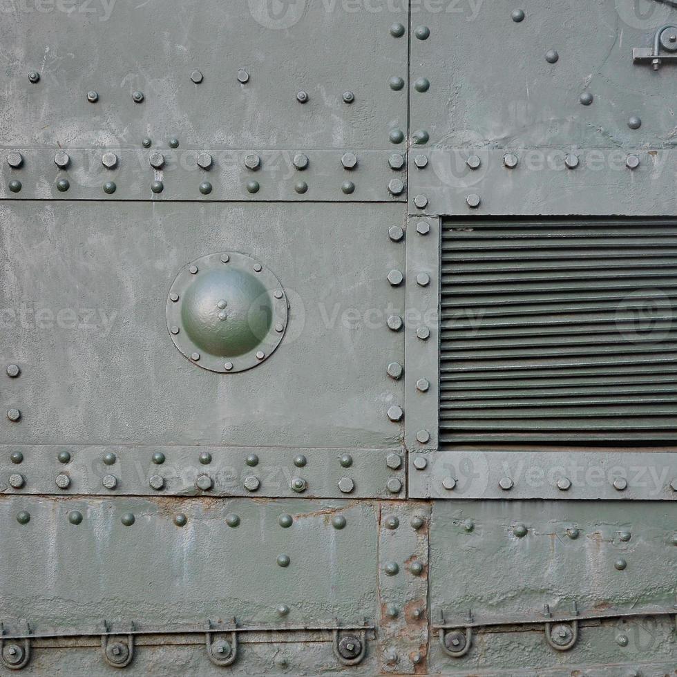 Texture of tank side wall, made of metal and reinforced with a multitude of bolts and rivets photo