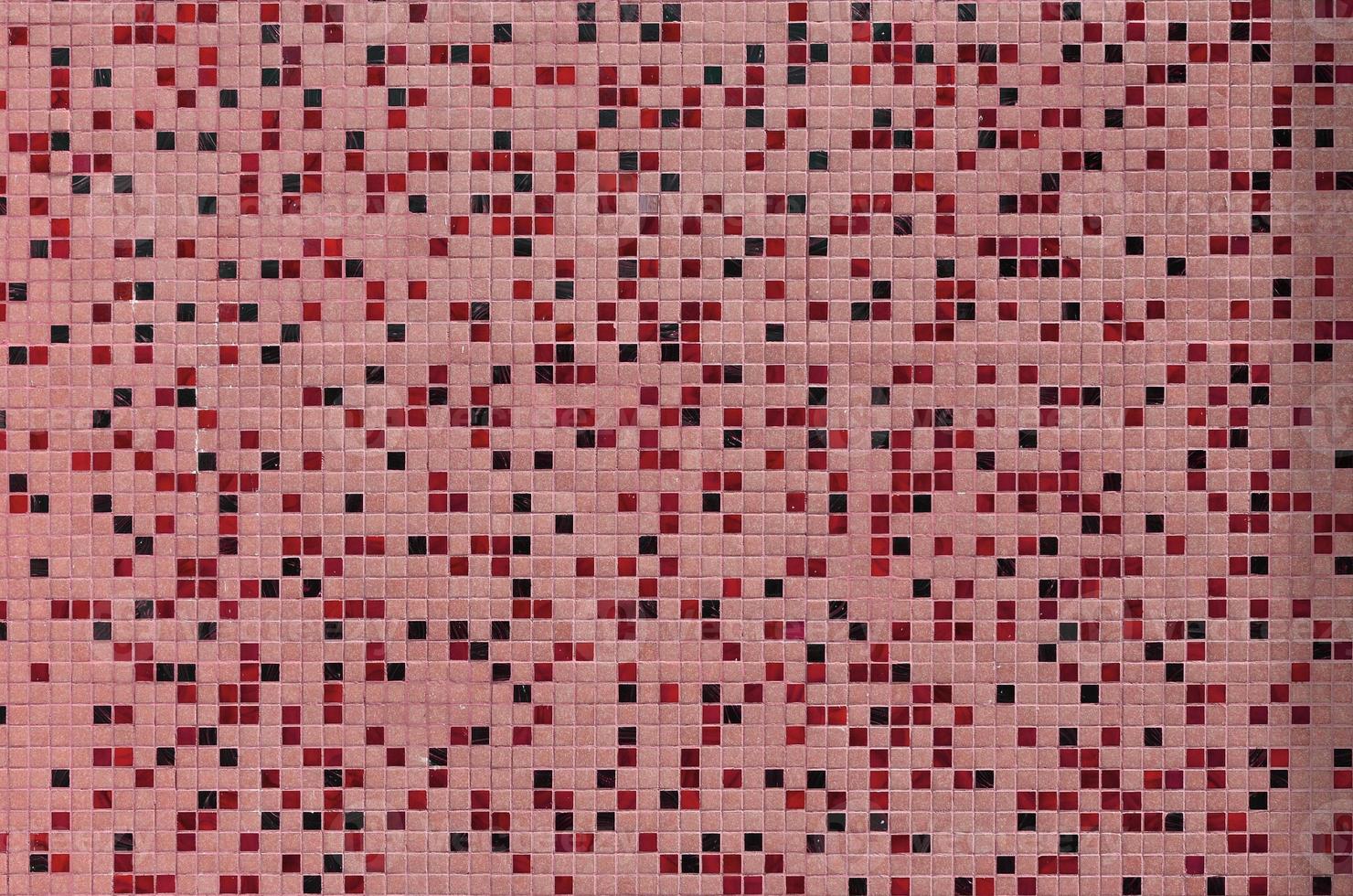 The texture of the wall, decorated with a mosaic of various small square tiles. Abstract pattern of ceramic tiles on the wall photo