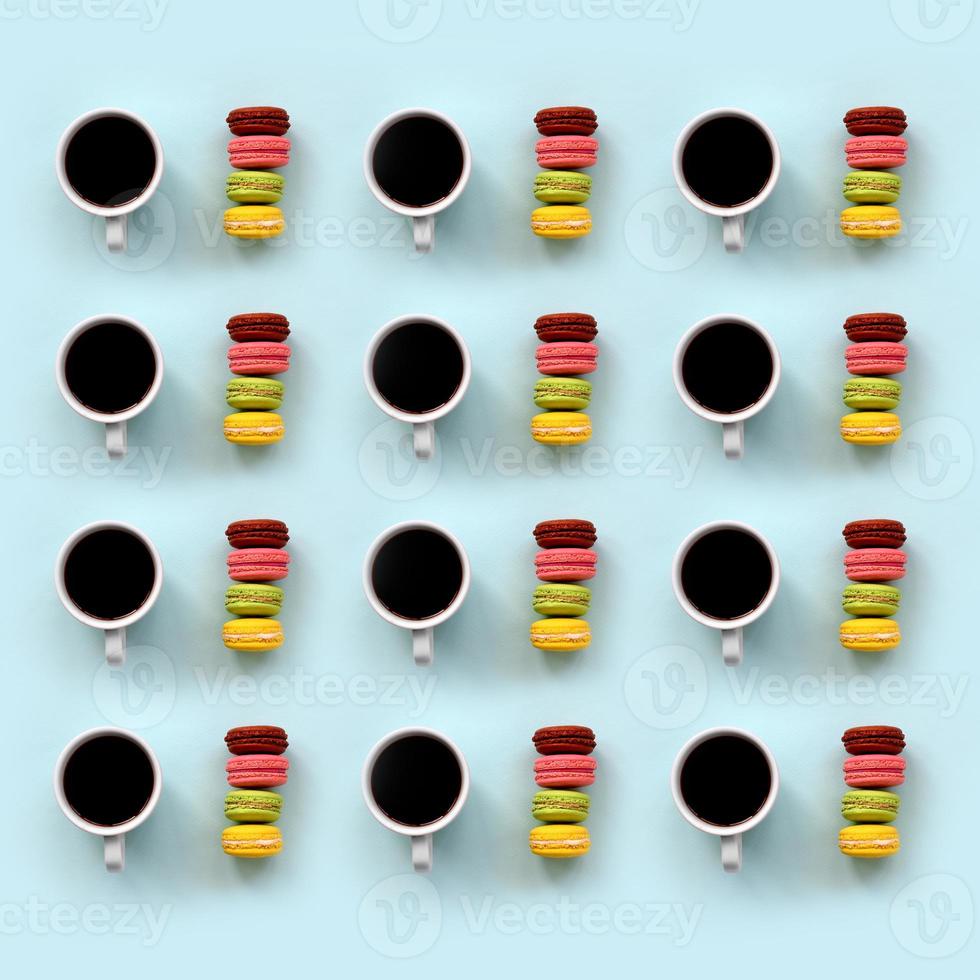 A pattern of many colorful dessert cake macaroon and coffee cups on trendy pastel blue background top view. Flat lay composition photo