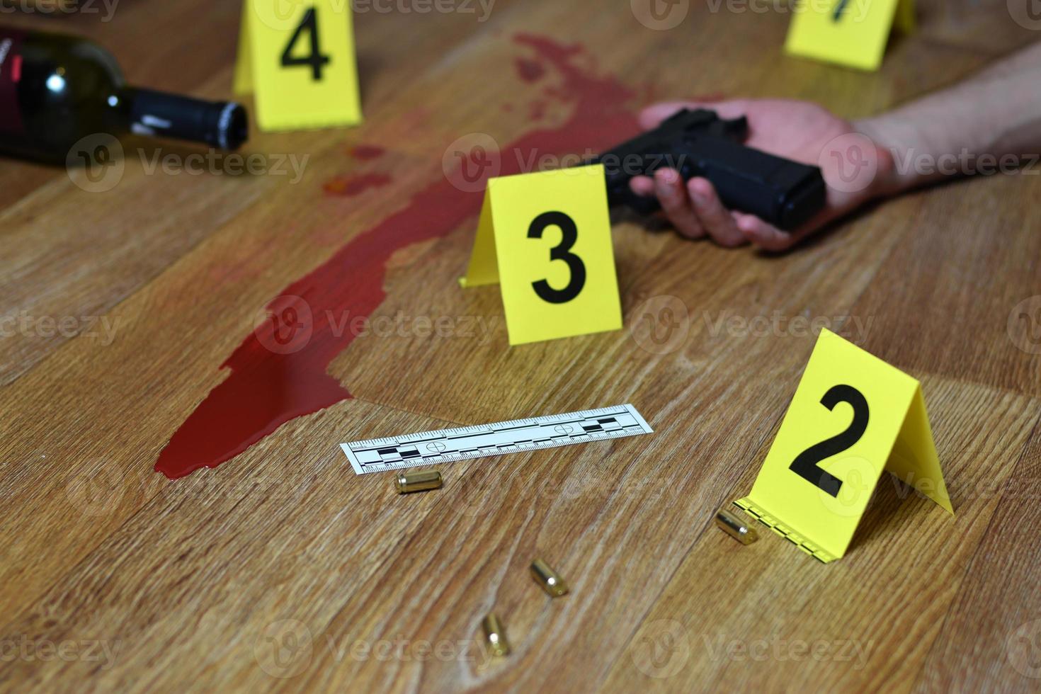 Bloody crime scene with dead body and gun on floor. Many crime scene investigation markers indoors photo