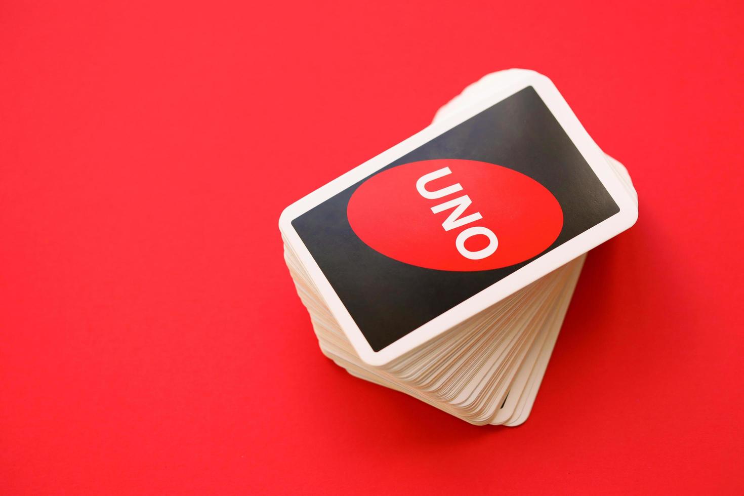 TERNOPIL, UKRAINE - MAY 15, 2022 Many colorful UNO game cards on red background. UNO is an American shedding-type card game that is played with a specially printed deck photo